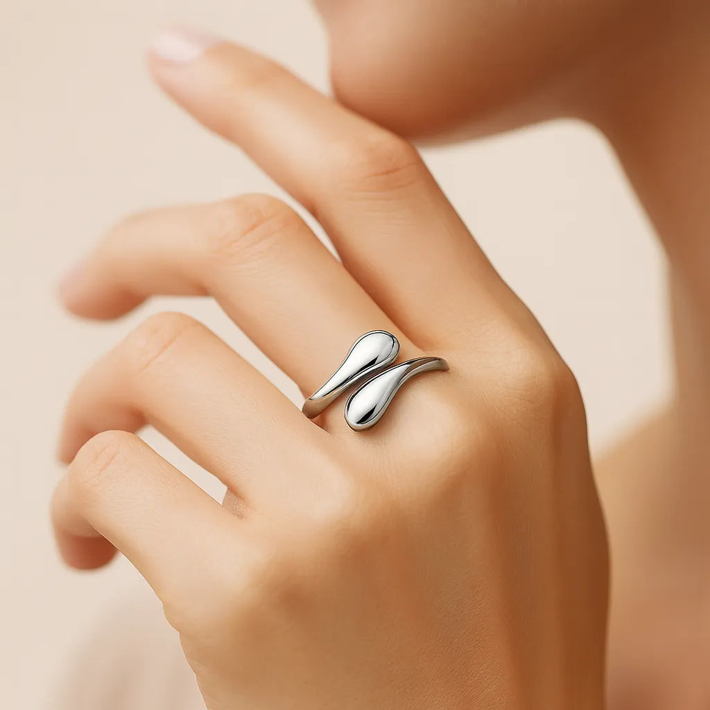 Silver ring on a hand against a neutral background