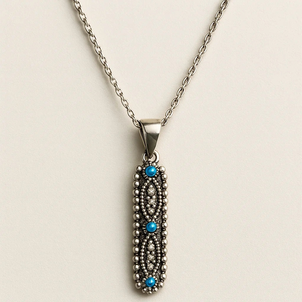 Silver necklace with a decorative pendant featuring blue stones on a beige background