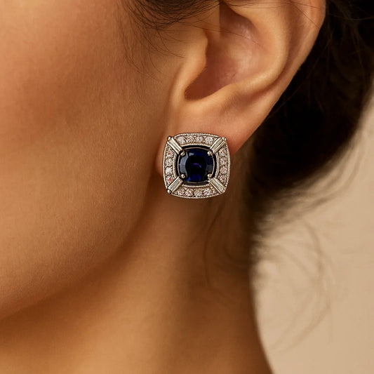 Close-up of an earring with a blue gemstone worn by a person.