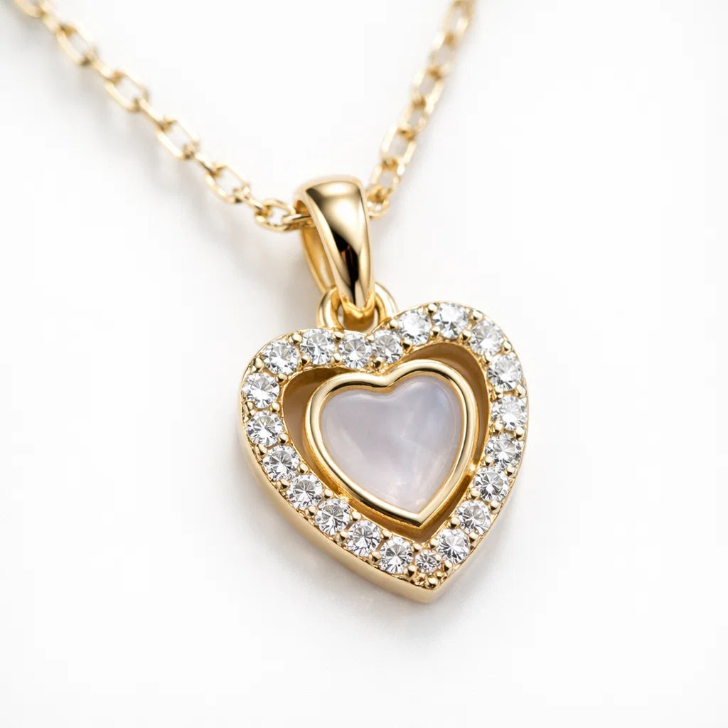 Gold heart-shaped necklace with a clear gemstone on a white background