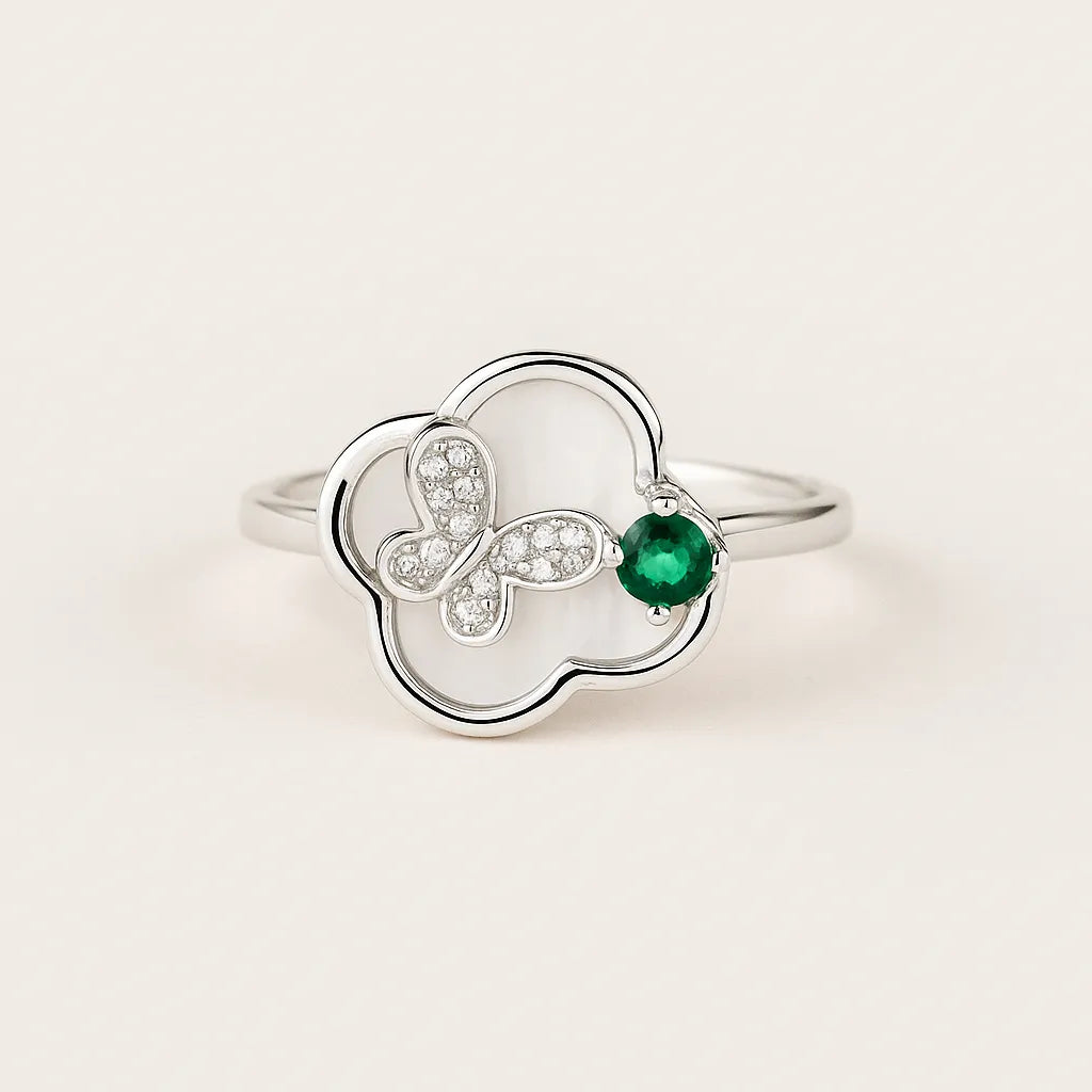 Silver ring with a green gemstone on a light beige background
