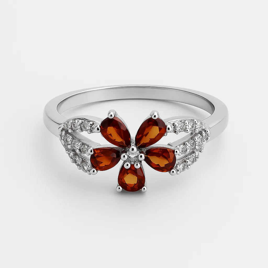 Silver ring with a flower-shaped gemstone on a white background