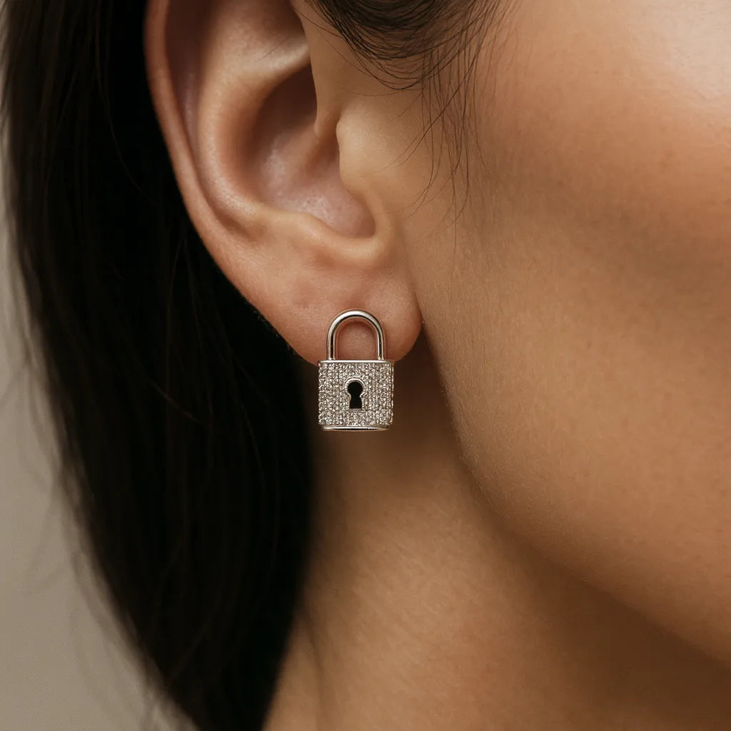 Silver lock-shaped earring worn by a person with dark hair.