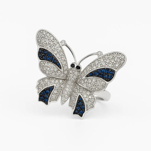 Butterfly-shaped ring with blue and clear gemstones on a white background