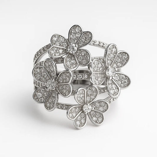 Silver ring with floral designs and clear stones on a white background