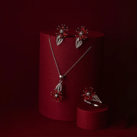 Women's 925 silver ruby red Zircon jewelry set from UAE brand. Includes a ring, stud earrings, and necklace pendant, all featuring a central floral motif with marquise red Zircon and a white Zircon border.