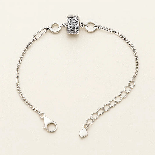 Silver bracelet with a clasp on a light beige background
