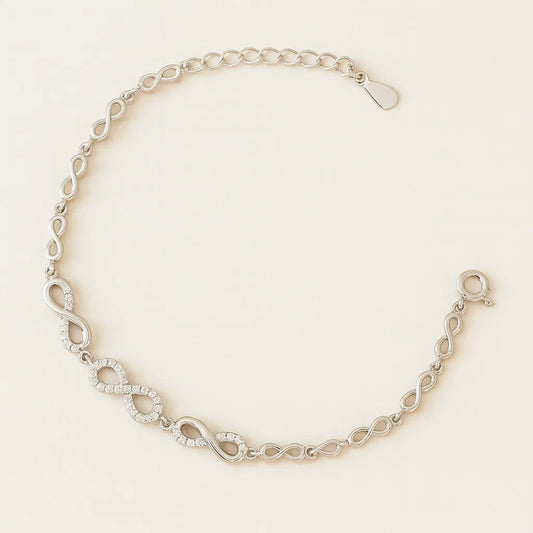 Silver bracelet with interlocking links on a beige background