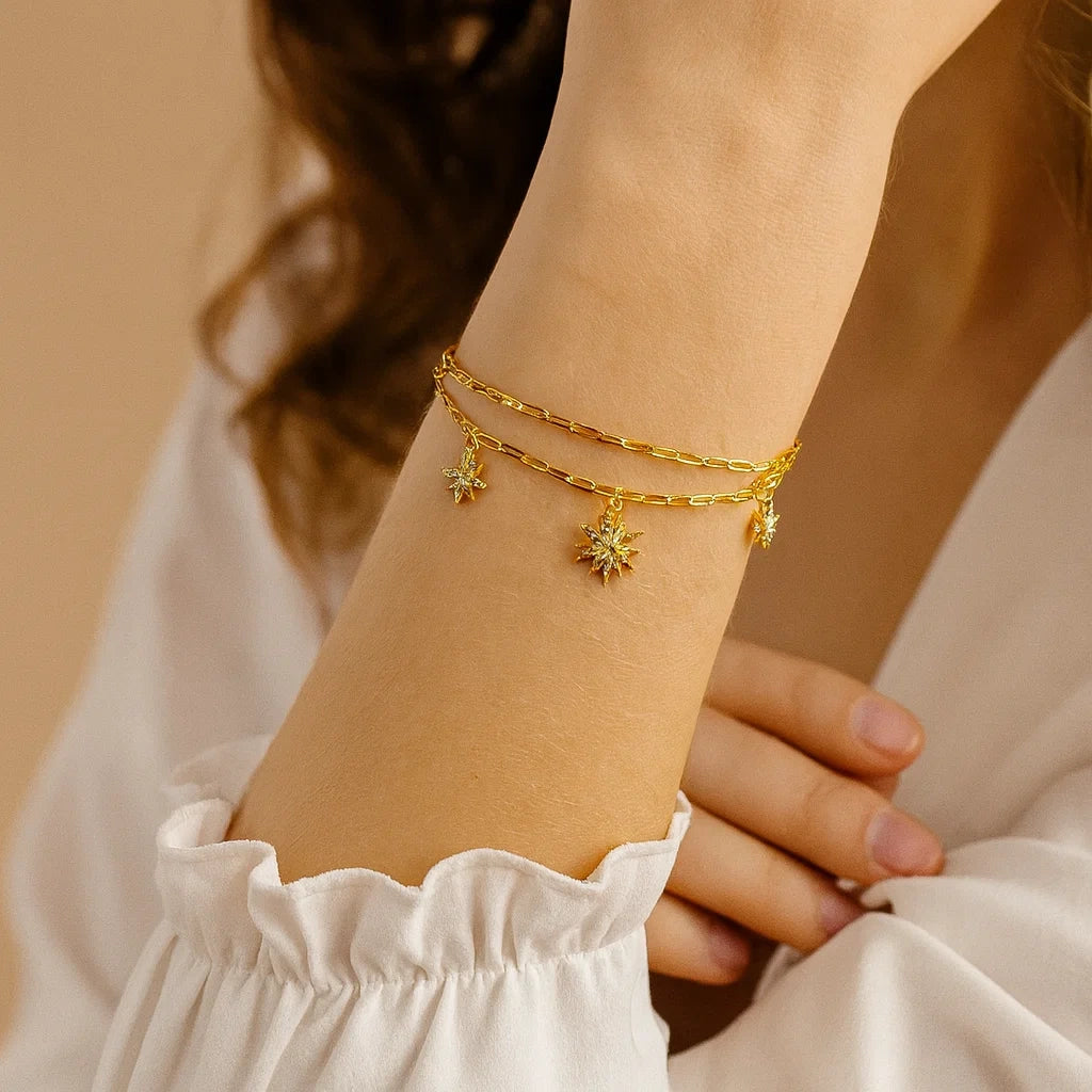 Women's 925 silver gold tone layered bracelet from UAE brand. Features multiple delicate chains with dangling pave Zircon starburst charms.