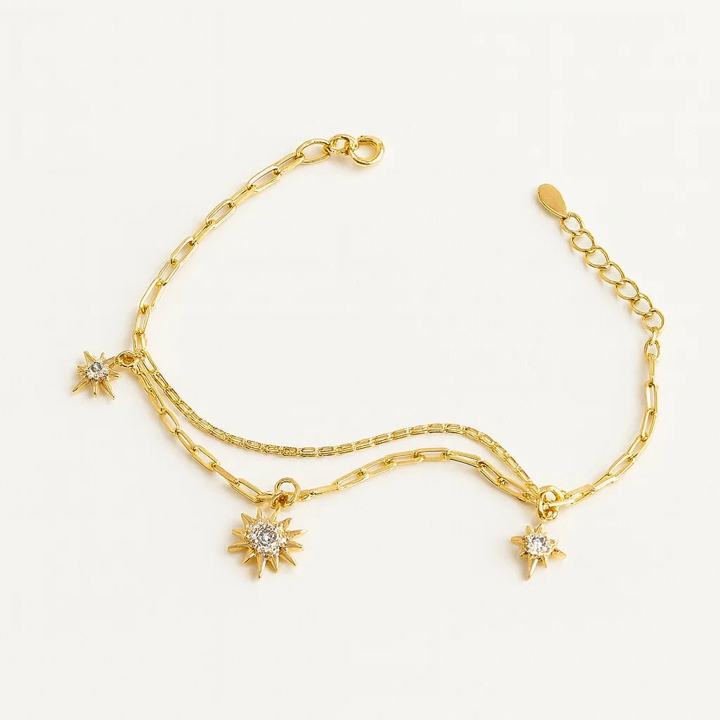 Women's 925 silver gold tone layered bracelet from UAE brand. Features multiple delicate chains with dangling pave Zircon starburst charms.