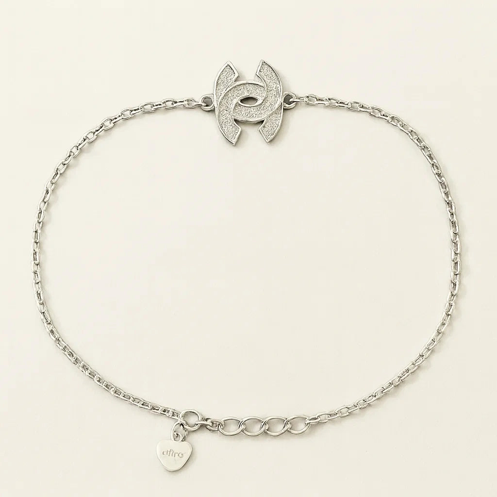 Silver bracelet with a heart-shaped tag on a light beige background