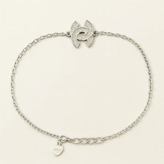 Silver bracelet with a heart-shaped tag on a light beige background