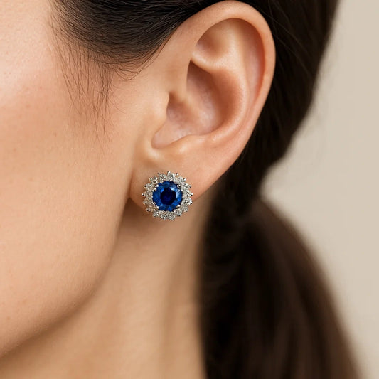Close-up of an ear wearing a blue gemstone earring with a blurred background