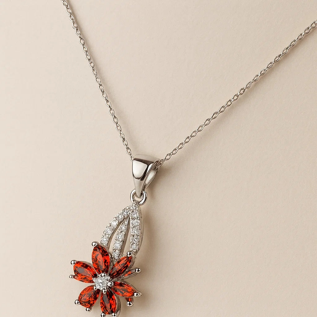 Floral pendant with red gemstones and a diamond on a beige background