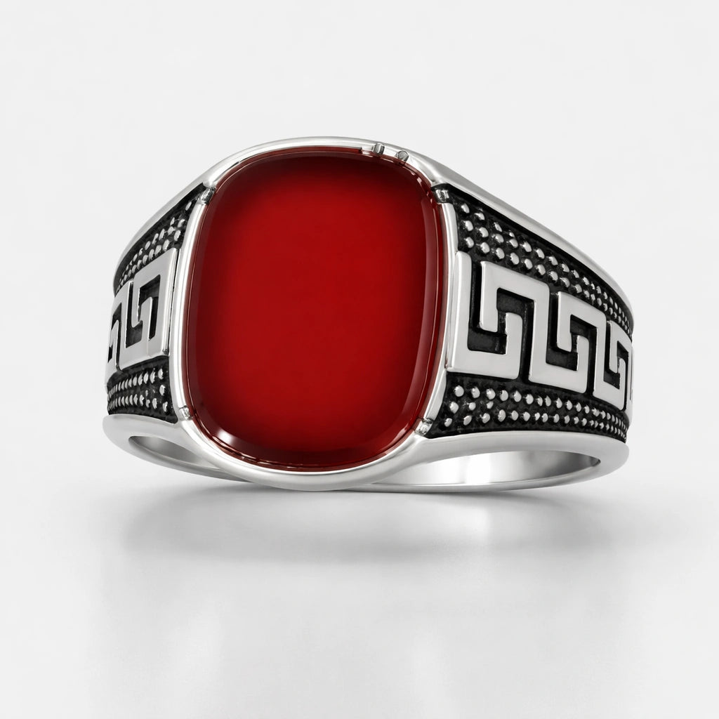 Silver ring with a red stone on a white background