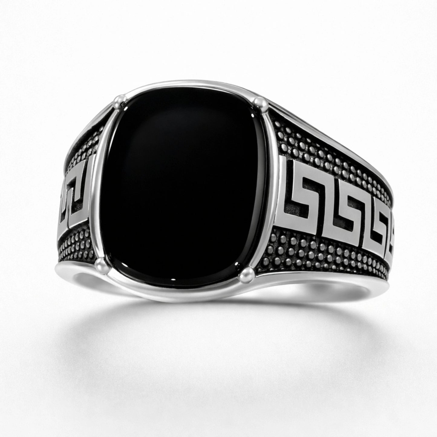 Silver ring with black stone and intricate design on a white background