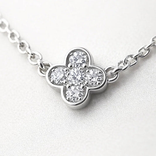 Diamond necklace with a clover-shaped pendant on a light gray background
