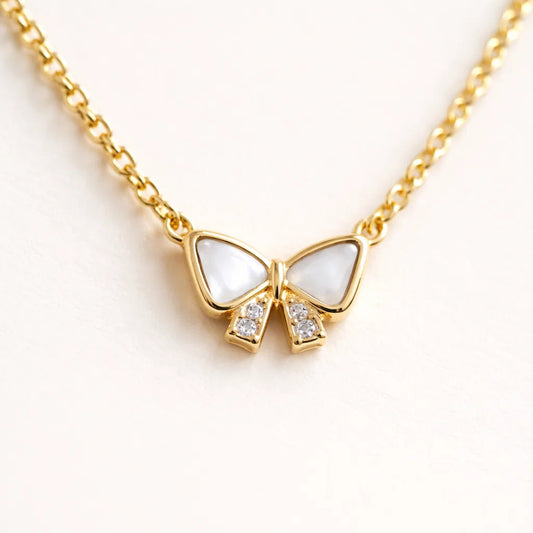 Gold necklace with a butterfly pendant on a white background
