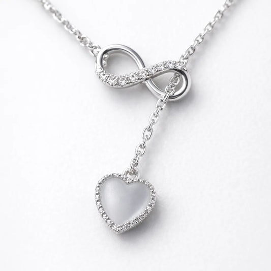 Silver necklace with an infinity symbol and heart pendant on a white background