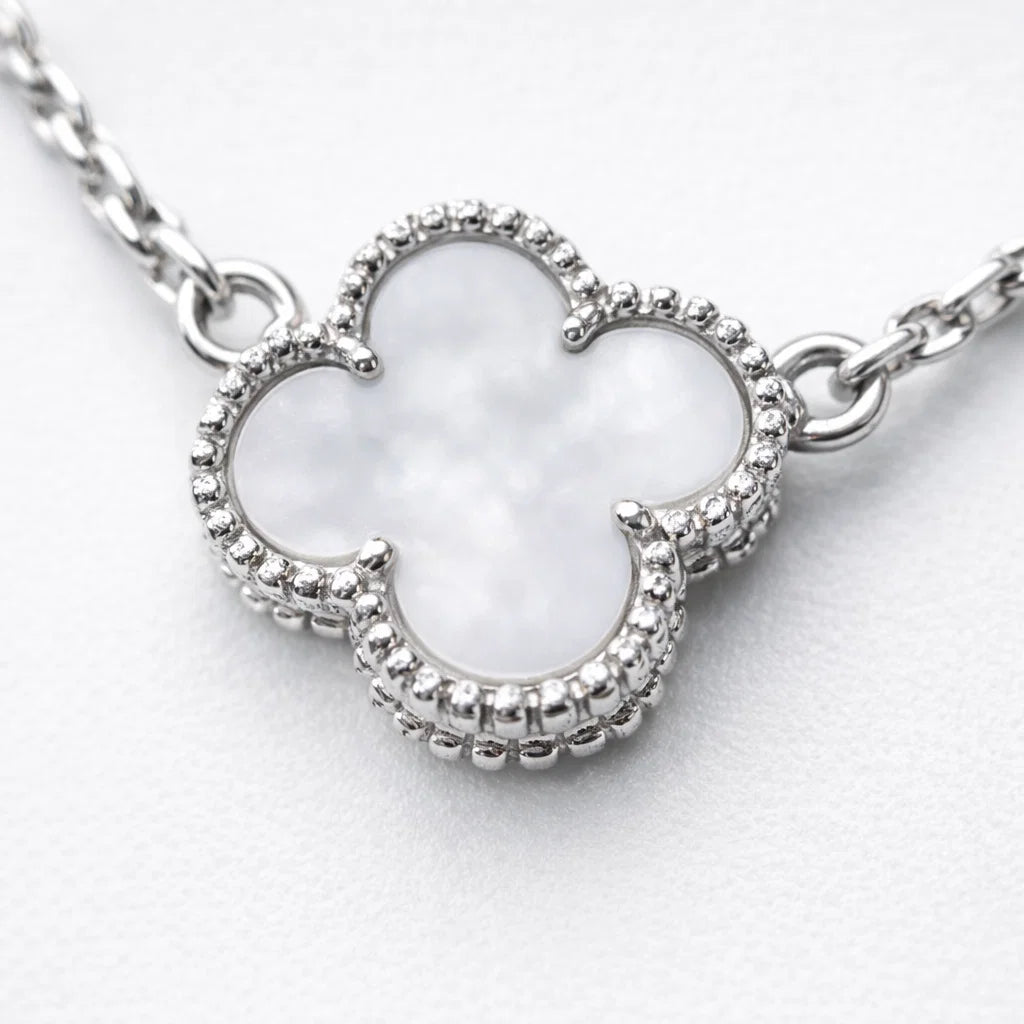 Silver necklace with a clover-shaped pendant on a white background